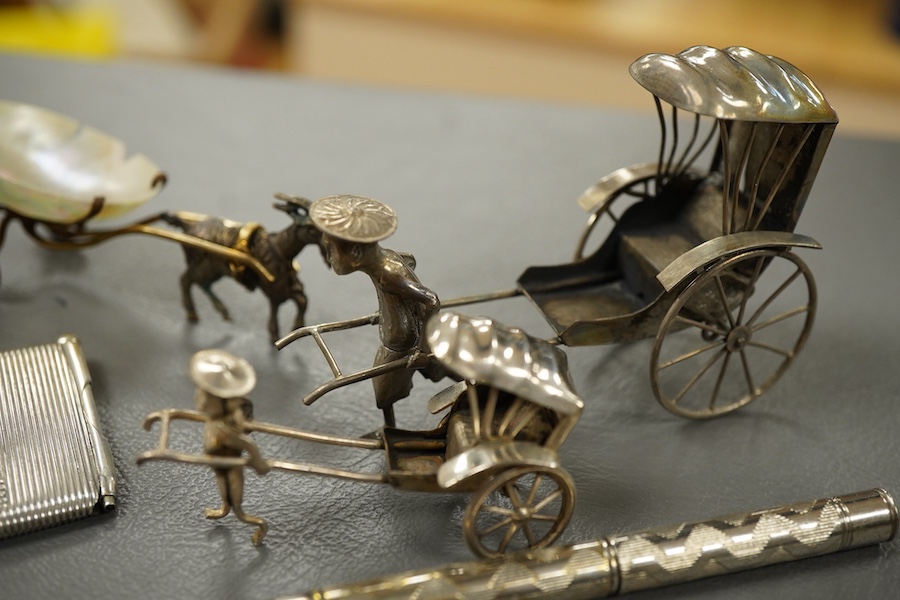 Sundry small silver and other items including a pig pin cushion, Adie & Lovekin, Birmingham, 1906, 45mm, a silver circular stamp case, a silver vesta case, a small sterling mounted notecase, three small metal rickshaws,